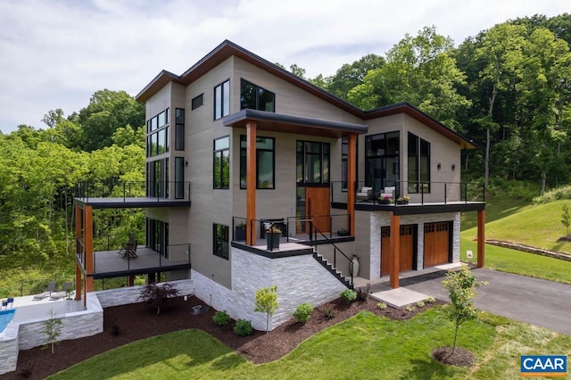 rear view of house featuring a lawn and a garage