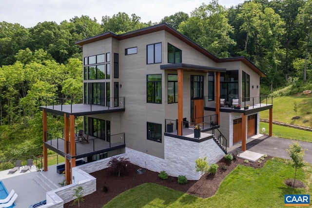 back of house featuring a garage and a yard