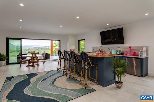 225 Cherry Ridge Ln, Lexington, VA 24450 - kitchen with light tile patterned floors, kitchen peninsula, a breakfast bar area, and stainless steel refrigerator