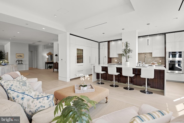 dining room with light hardwood / wood-style floors, a tray ceiling, and a healthy amount of sunlight