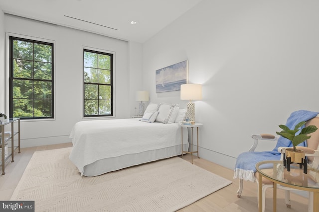 bedroom featuring vaulted ceiling and light hardwood / wood-style flooring