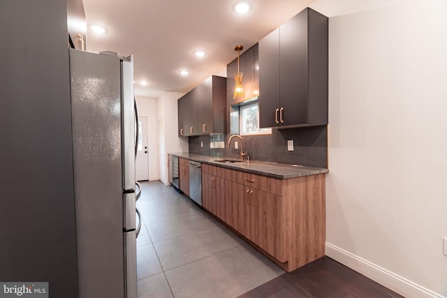 kitchen featuring decorative backsplash, appliances with stainless steel finishes, decorative light fixtures, and sink