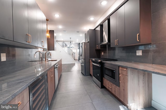 kitchen with sink, hanging light fixtures, beverage cooler, decorative backsplash, and appliances with stainless steel finishes