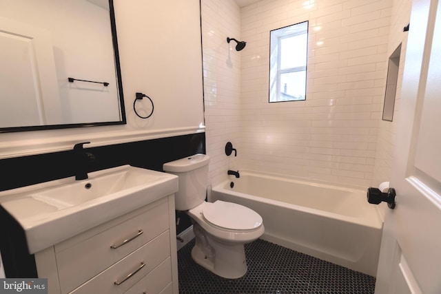 full bathroom with vanity, tiled shower / bath combo, and toilet