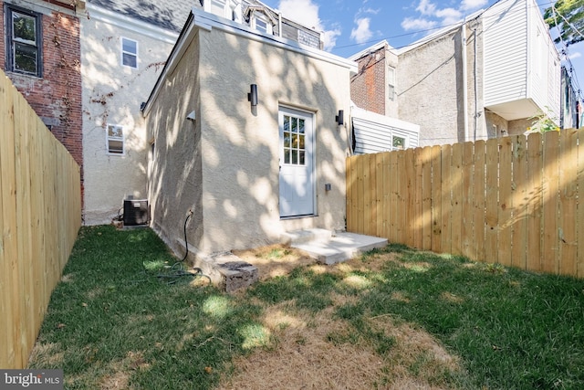 back of house featuring a lawn and cooling unit