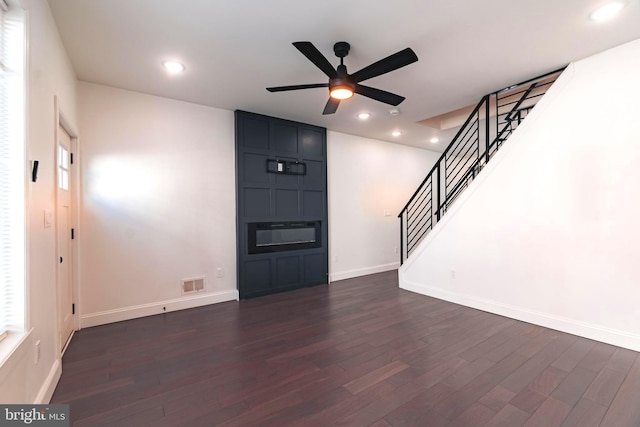 unfurnished living room featuring ceiling fan and dark hardwood / wood-style flooring