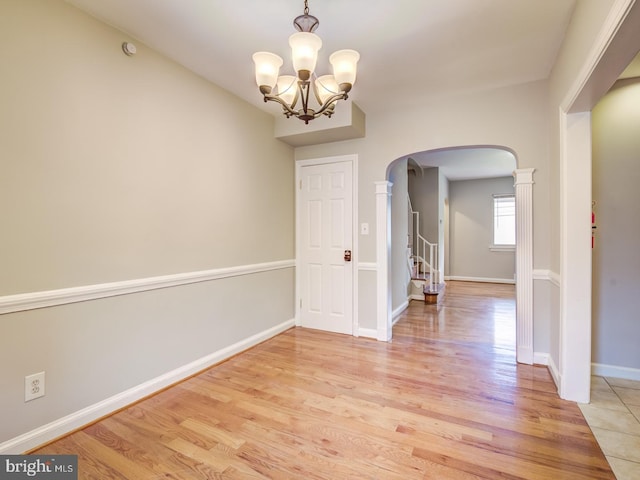 spare room with a chandelier and light hardwood / wood-style floors