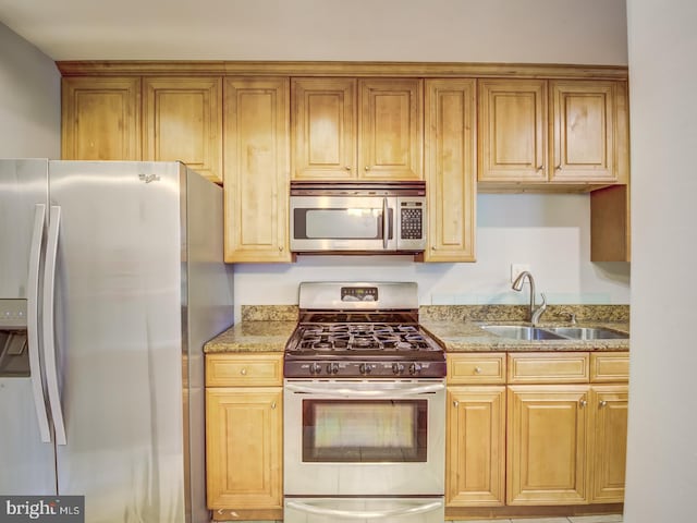 kitchen with sink, light stone countertops, and stainless steel appliances