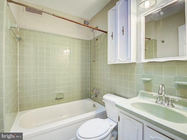 full bathroom with tasteful backsplash, vanity, tile walls, toilet, and tiled shower / bath