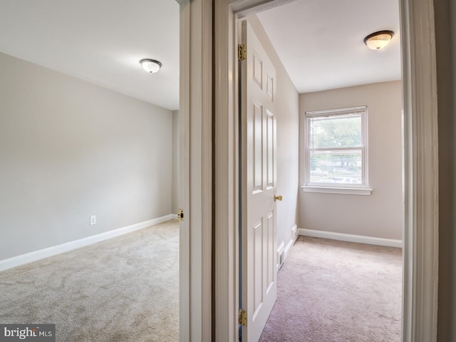 corridor featuring light carpet and vaulted ceiling