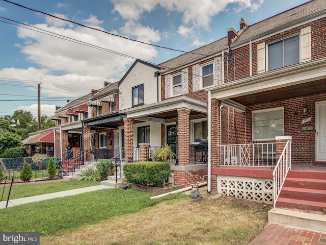 multi unit property featuring a front yard and a porch