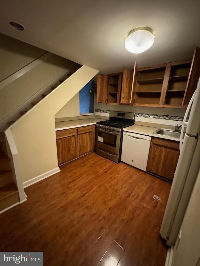 kitchen with hardwood / wood-style floors, white appliances, and sink