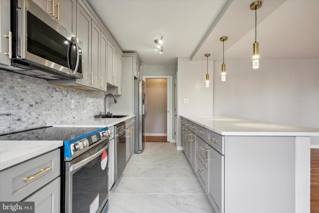 kitchen featuring gray cabinetry, sink, hanging light fixtures, tasteful backsplash, and appliances with stainless steel finishes