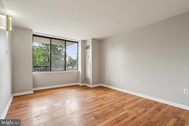 empty room with light hardwood / wood-style flooring