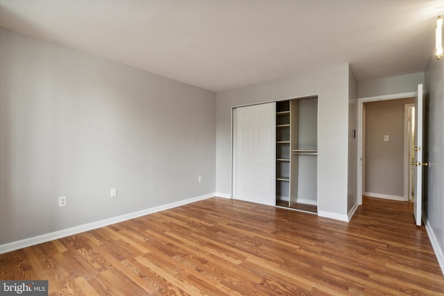 unfurnished bedroom with hardwood / wood-style flooring and a closet