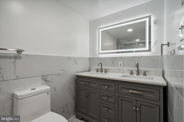 bathroom featuring vanity, tile walls, and toilet