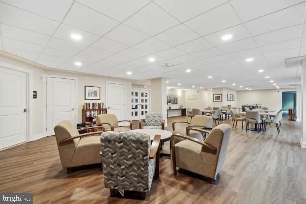 living room featuring a paneled ceiling and wood-type flooring