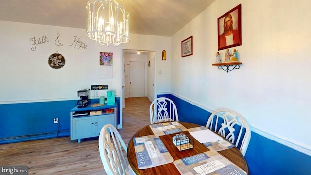 dining area with hardwood / wood-style floors and a notable chandelier