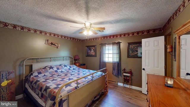 bedroom featuring a textured ceiling, hardwood / wood-style flooring, baseboard heating, and ceiling fan