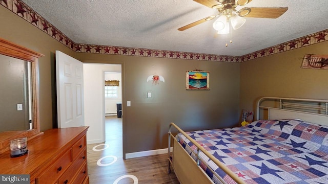 bedroom with ceiling fan, light wood-type flooring, and a textured ceiling