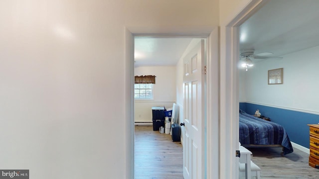 hallway featuring light hardwood / wood-style floors and baseboard heating