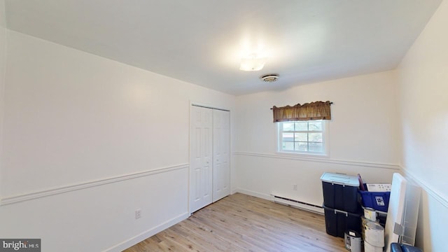 interior space with baseboard heating and light hardwood / wood-style flooring