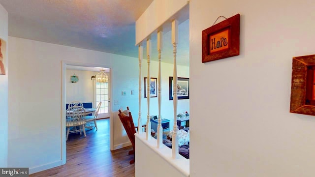 hall featuring hardwood / wood-style flooring and a notable chandelier