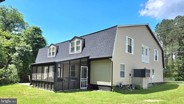 back of property featuring a sunroom and a yard