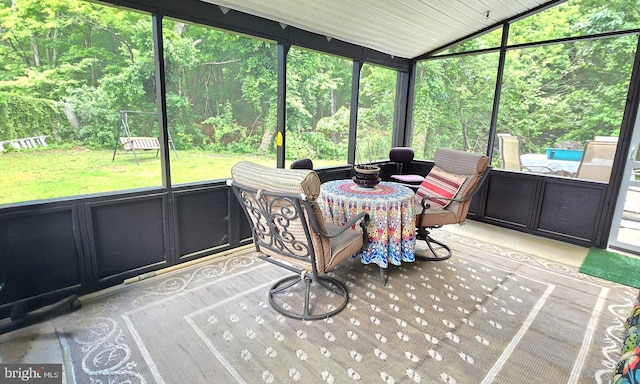 sunroom with a healthy amount of sunlight and vaulted ceiling