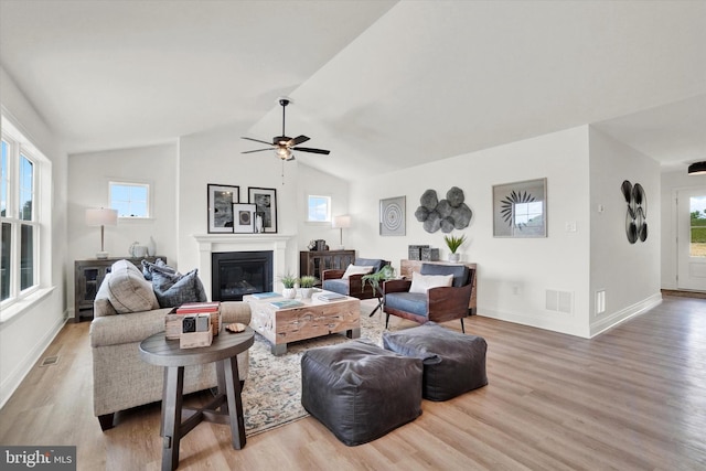 living room featuring light hardwood / wood-style floors, vaulted ceiling, plenty of natural light, and ceiling fan