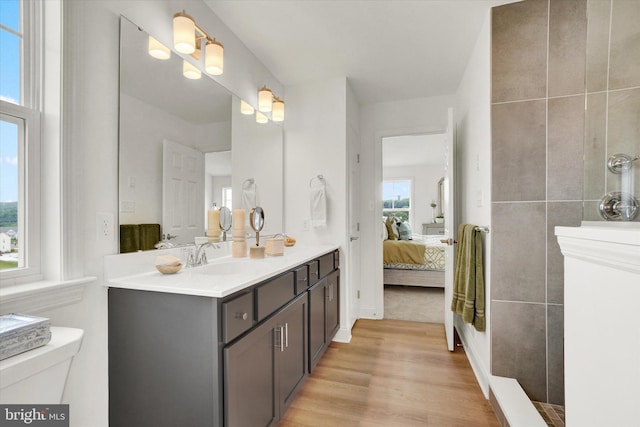 bathroom with hardwood / wood-style floors, vanity, a healthy amount of sunlight, and toilet