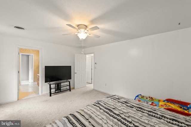 carpeted bedroom featuring ceiling fan and a textured ceiling