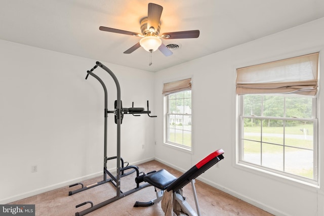 workout area featuring ceiling fan and light colored carpet