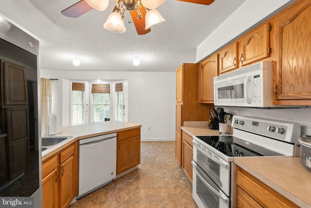 kitchen with a textured ceiling, ceiling fan, white appliances, and sink