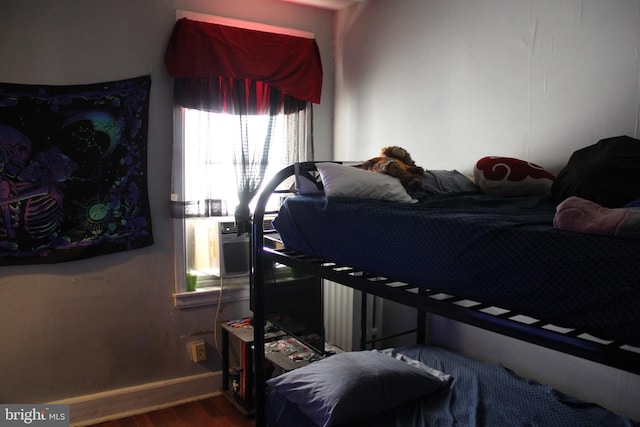 bedroom with hardwood / wood-style floors and cooling unit