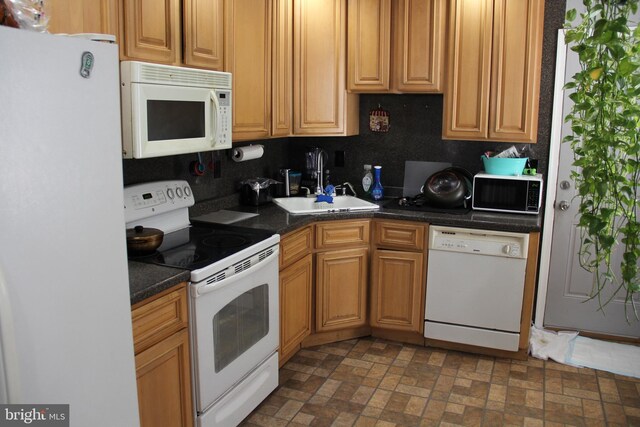 kitchen with decorative backsplash, sink, and white appliances