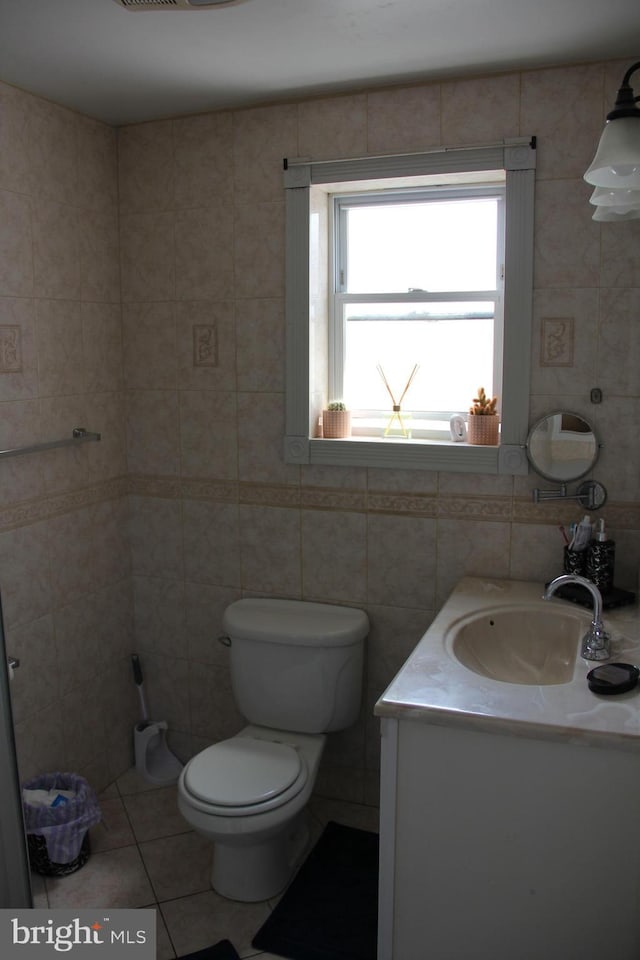 bathroom with tile patterned floors, vanity, tile walls, and toilet