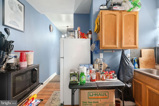 kitchen featuring light hardwood / wood-style floors and white fridge