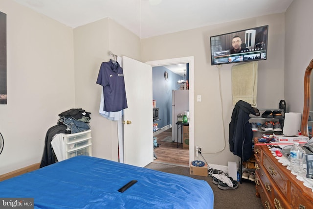 bedroom with carpet floors and white refrigerator