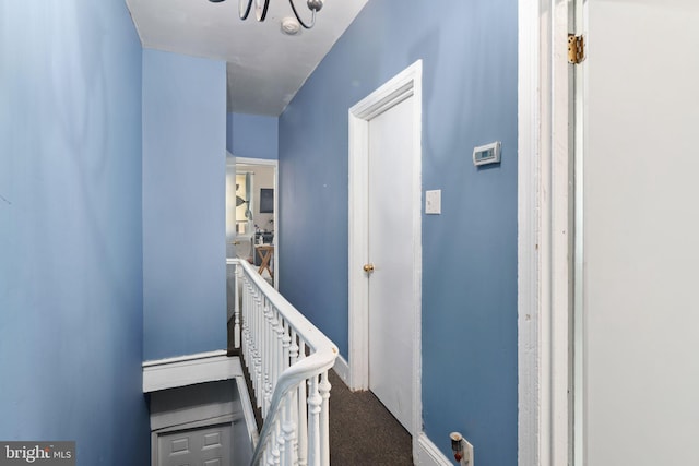 stairway featuring a chandelier and carpet floors