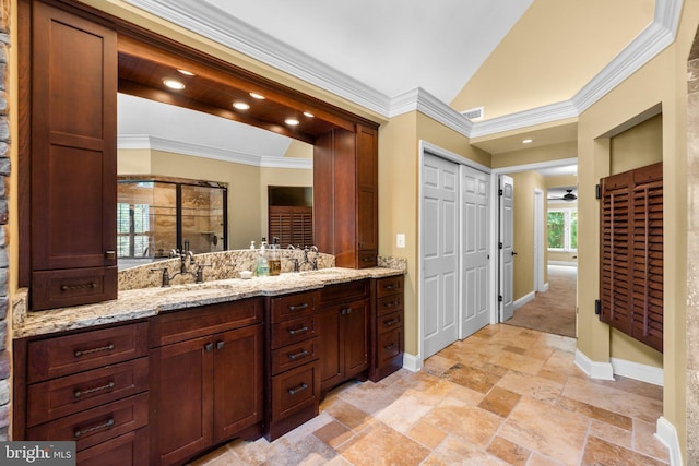 bathroom featuring vanity, a shower with shower door, and ornamental molding