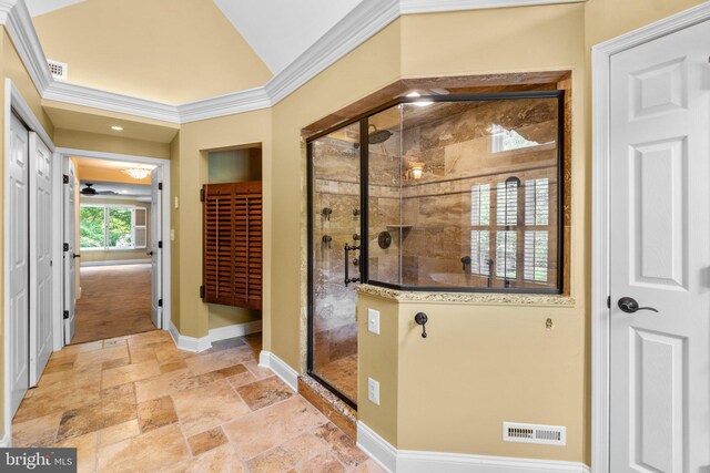 bathroom featuring a shower with door and crown molding