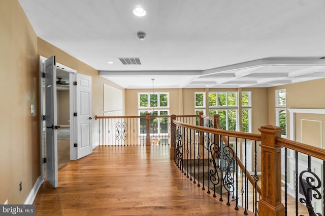 corridor with beamed ceiling, light wood-type flooring, and coffered ceiling