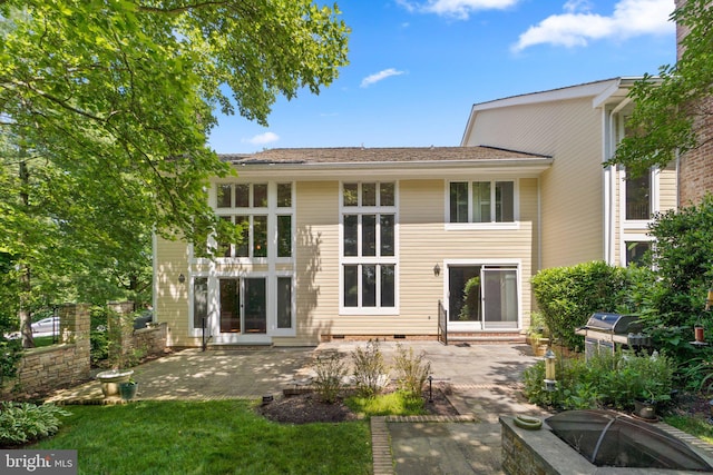 back of property featuring a patio and a fire pit