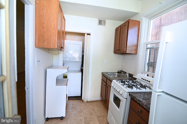 kitchen featuring light tile patterned floors, white appliances, tasteful backsplash, and sink