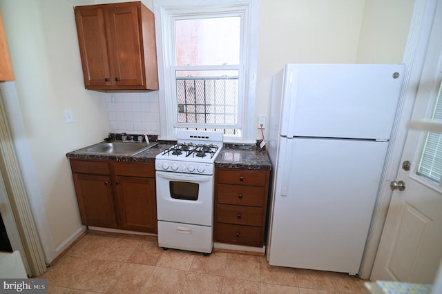 kitchen featuring backsplash, white appliances, and sink