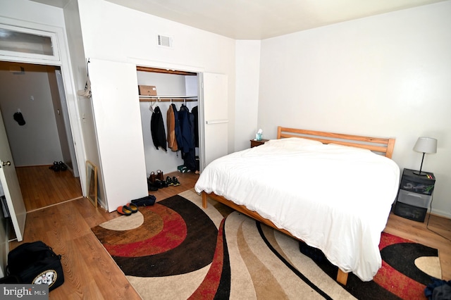 bedroom with wood-type flooring and a closet