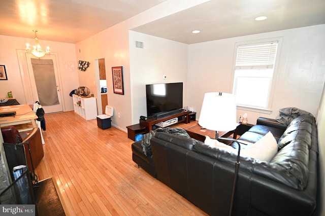 living room with a notable chandelier and light wood-type flooring