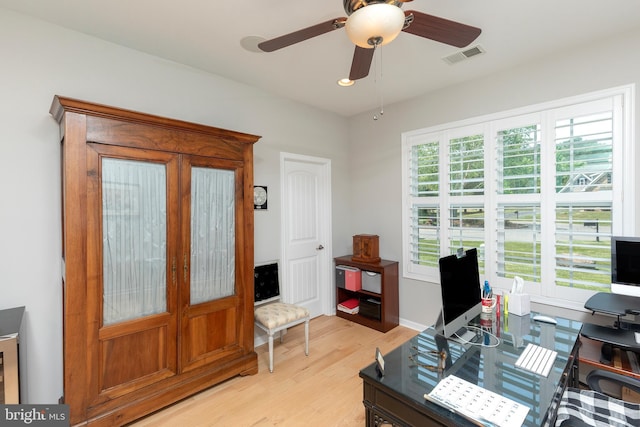 office with light hardwood / wood-style flooring and ceiling fan