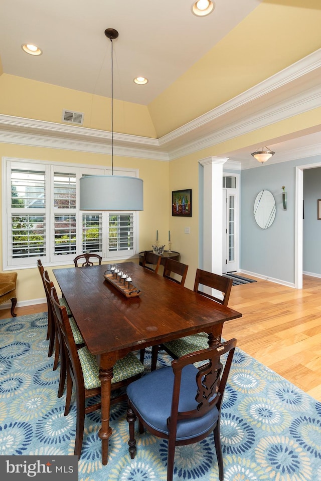 dining space featuring hardwood / wood-style floors, crown molding, a wealth of natural light, and a tray ceiling